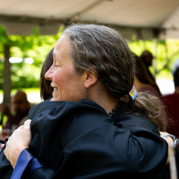 Two BardBac grads embrace at commencement.