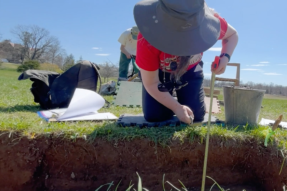 Archaeology student taking a measurement.