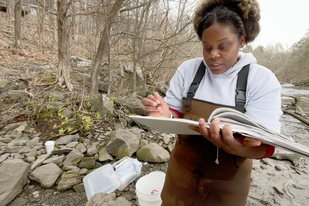 A student taking notes in the field.